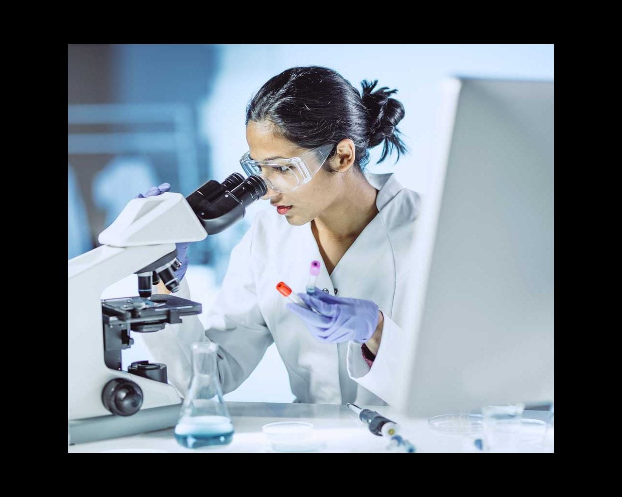woman looking into microscope